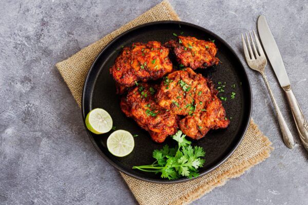 Tandoori,Chicken,Thighs,Garnished,With,Fresh,Cilantro,,Served,With,Lemon